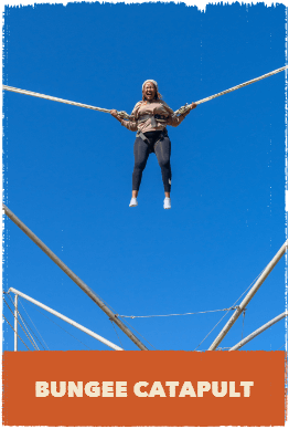 Woman in mid having been launched by bungee catapult