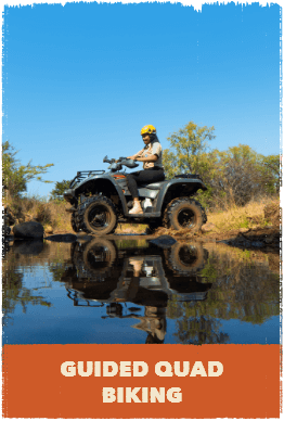 Woman driving quad bike through stream