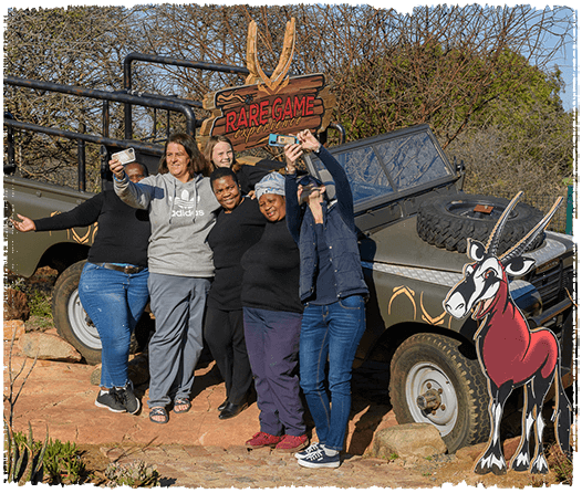 Group of people posing for photos and selfies infront of a parked Landrover